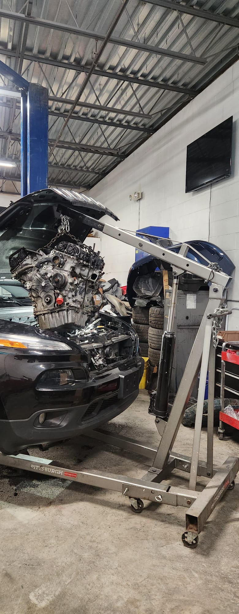 Engine suspended on hoist during rebuild
