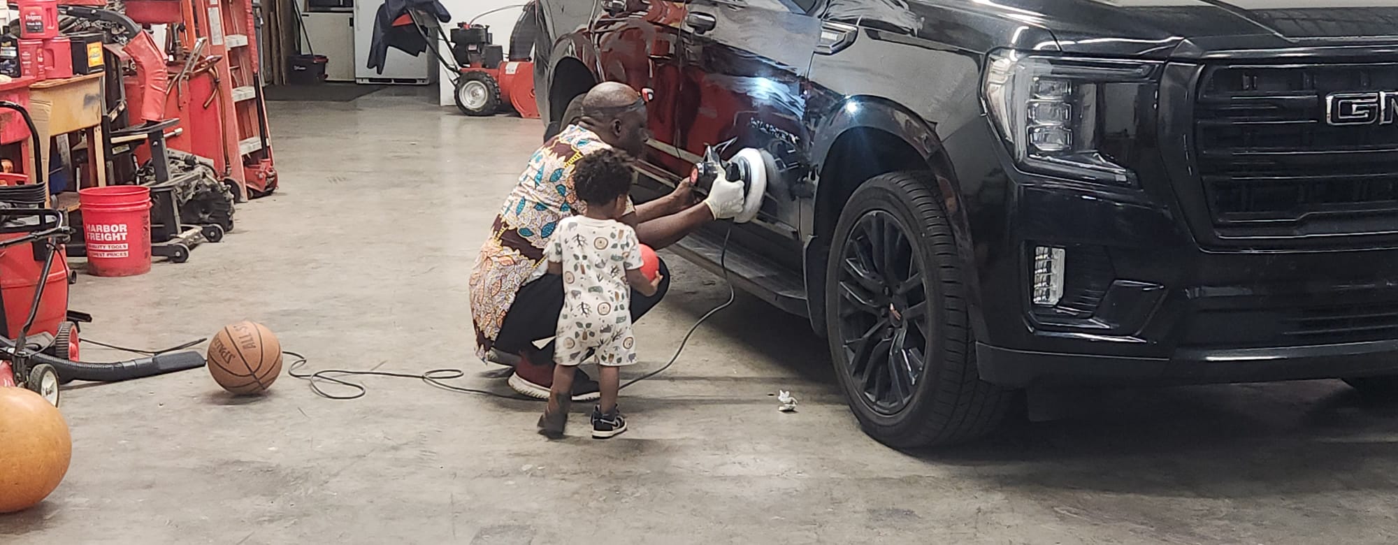 Detail polishing work on GMC Yukon fender
