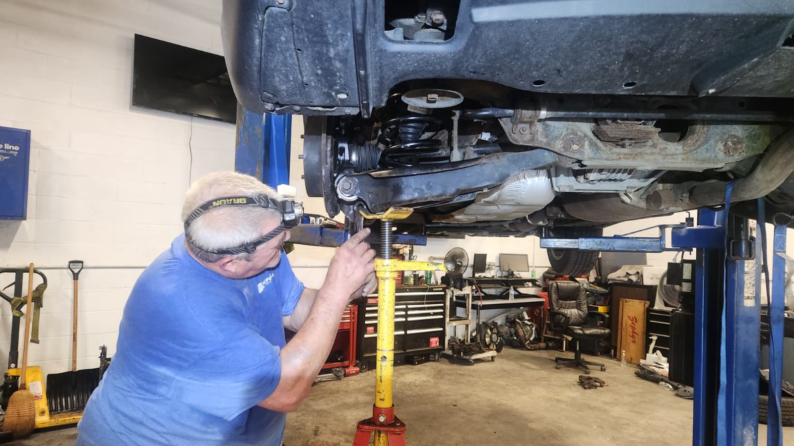 Technician working under lifted vehicle