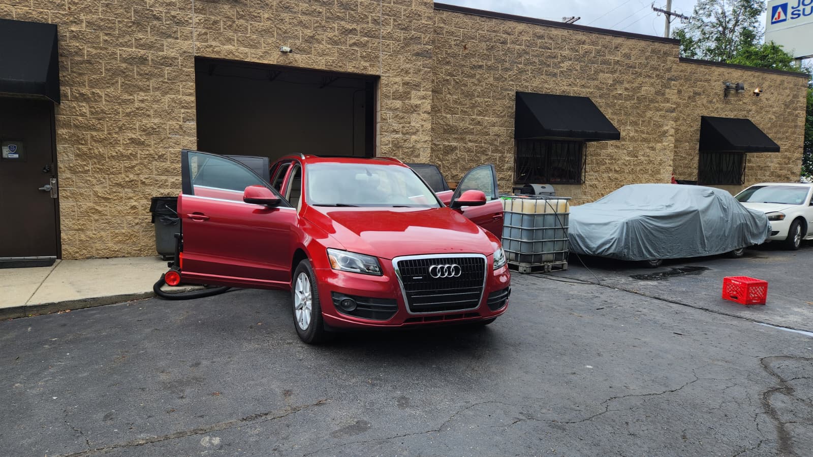 Red Audi Q5 being detailed outside the shop